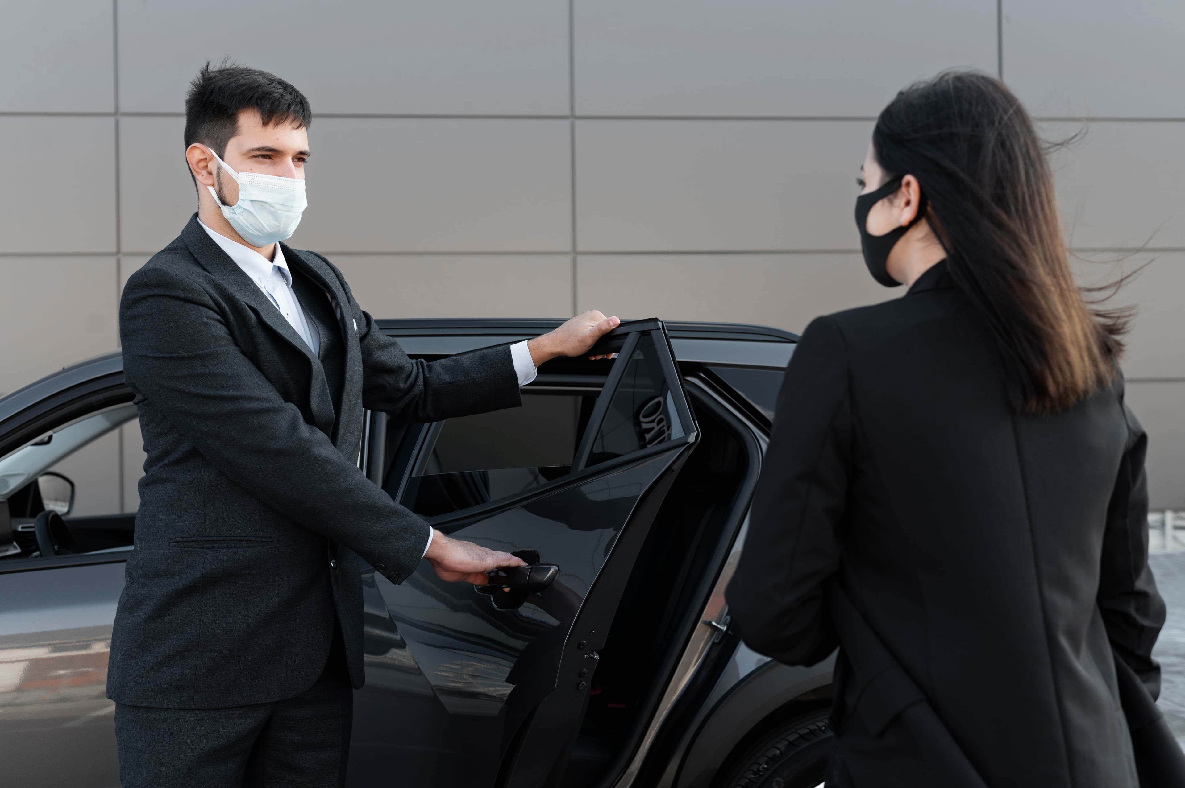 Chauffeur opening door for a client